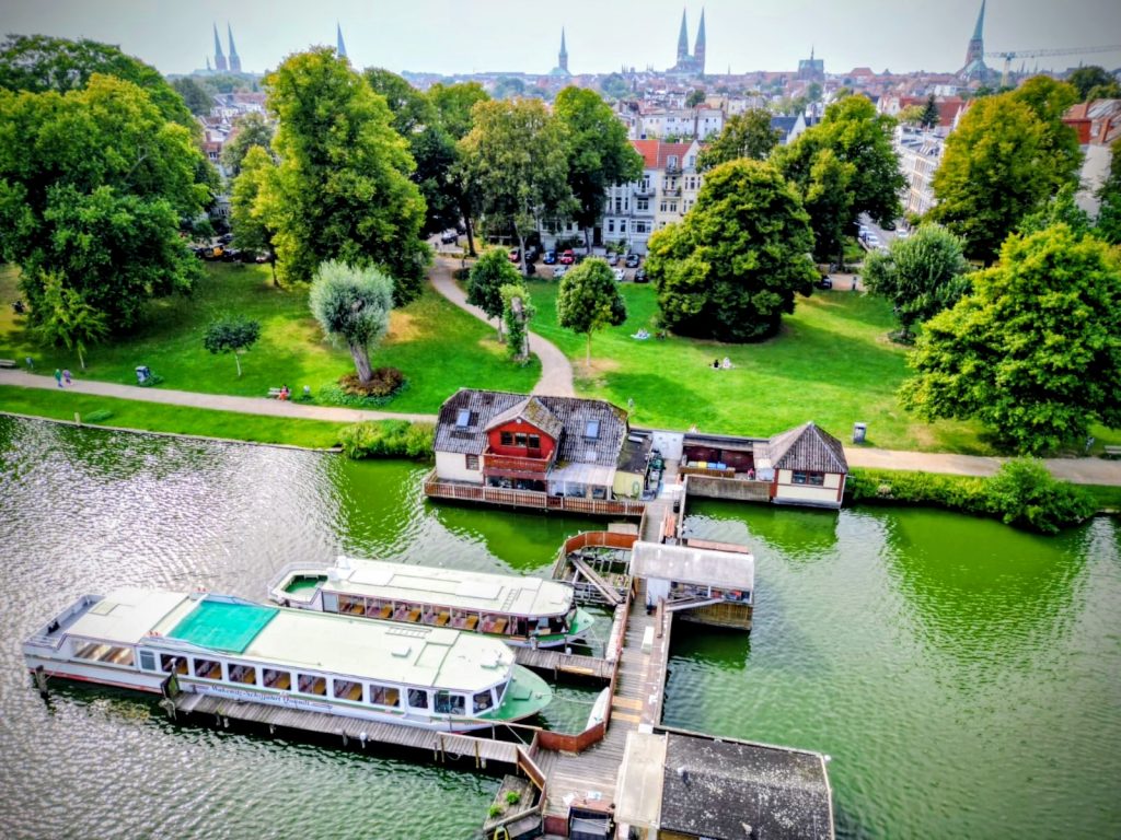 Luftbild zeigt Falkenwiese Lübeck mit Badeufer, Bootshaus, Parkplätzen und Wakenitz, aufgenommen über der Wakenitz