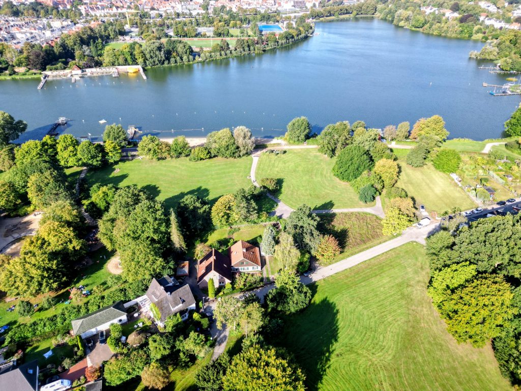Luftbild zeigt Drägerpark Lübeck und Wakenitzufer mit Naturstrand und Naturbad Marli, aufgenommen über dem Drägerpark