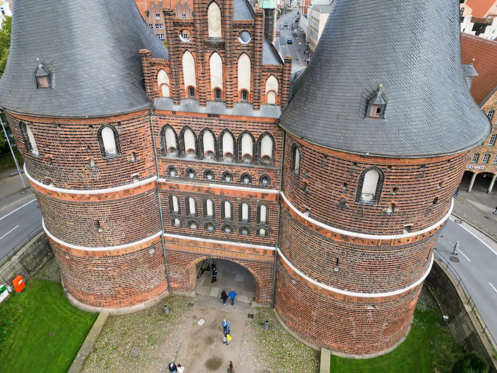 Luftbild zeigt Nahaufnahme des Lübecker Holstentormuseum, über dem Holstentorplatz aufgenommen