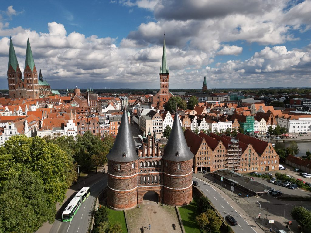 Holstentor, im Hintergrund die Lübecker Altstadt, mit dem Petrikirchturm, der Marienkirche und den alten Salzspeichern, Luftnahme der Lübecker altstadt