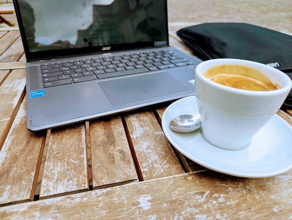 Lockeres Arbeiten am Notebook und einen Café Crema, Sitzen an der Straße, Café Fair bei Bohne